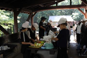 5年生が野外炊飯上で食材を切る様子