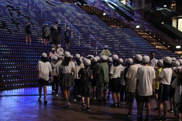 6年生が夜の京都駅階段を登る様子