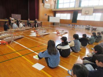 体育館で尺八とお箏の生演奏を聴く児童たちの様子