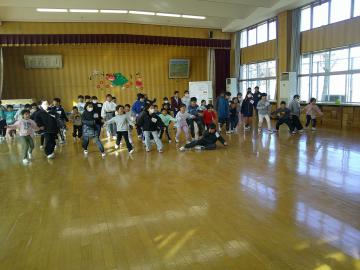 体育館で「だるまさんが転んだ」のゲームで動かずにじっとしている園児と小学5年生たちの様子