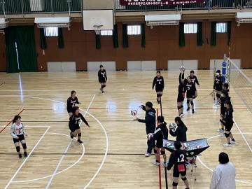 体育館で生徒たちが試合前にバレーの練習をする様子