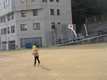 庭で子どもが凧あげをしています