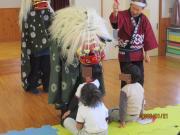 無病息災を願い児童が獅子舞にかまれる様子