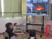 教室内で防災の授業を受ける1年生児童たちの様子。モニターを見ています。