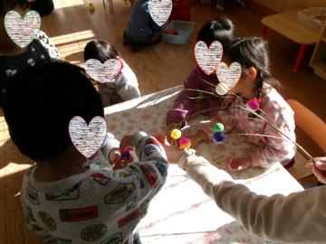 室内で3歳児がもち花を作っている様子