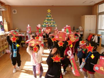 室内で3歳児がプレゼントをもらって喜んでいる様子