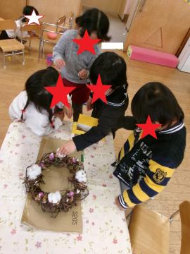 室内で3歳児がリースつくりをしている様子