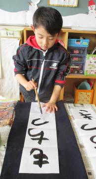 室内で書き初めをしている園児の様子