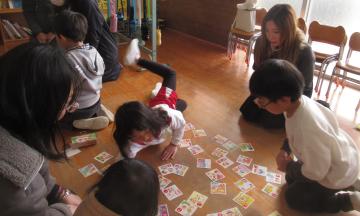 室内で親子でかるた遊びをしている園児たちの様子