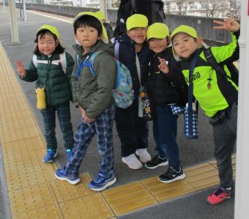 駅のホームで電車に乗って城東幼稚園に行こうとする園児たちの様子