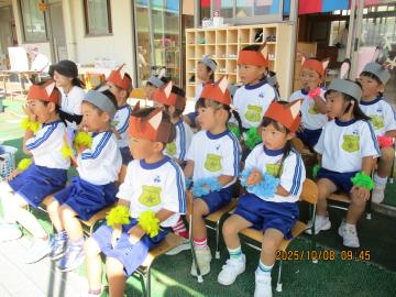 3歳児が園児席で他クラスの演技を見ている様子