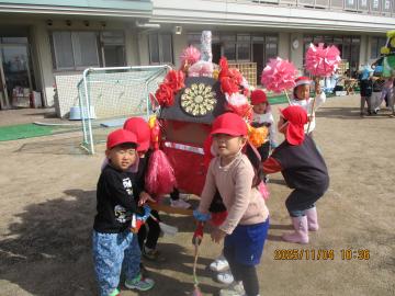園庭でやっさを担ぐ園児たちの様子