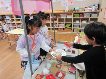 室内で模擬の売り買いをする園児たちの様子