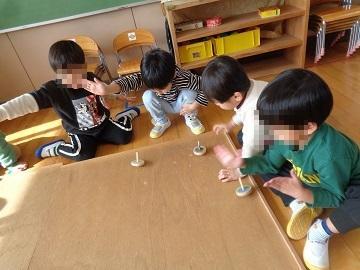 3歳児が手回しこまで遊んでいる写真