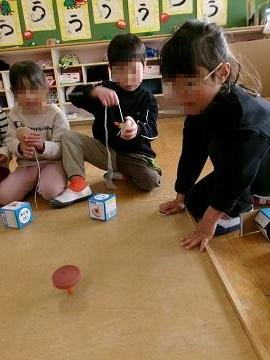 4歳児がこま回しで、きのこ回しをしている写真