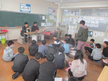 子どもたちが教室でゲストティーチャーの方に質問をしている様子