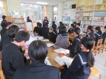 前之庄小学校の図書室で図書司書の話を聞く鹿谷中学校3年生の生徒たちの様子
