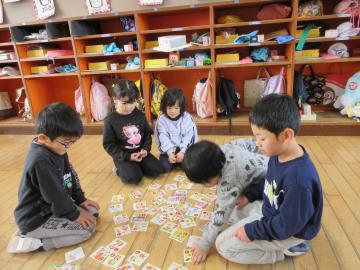 室内で4歳児がかるたをとっている様子