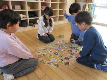 室内でかるた遊びしている4歳児たちの様子