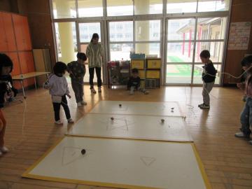 室内で鉄心コマで遊んでいる5歳児たちの様子