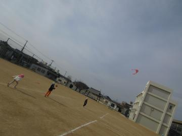 小学校の校庭で凧あげをする園児たちの様子