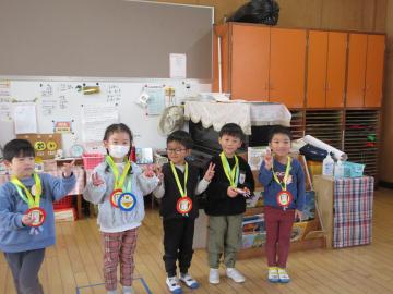 室内で、かるた大会の入賞者がメダルをもらっている様子