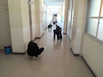 生徒が廊下で雑巾掛けをして、一生懸命掃除をしている様子