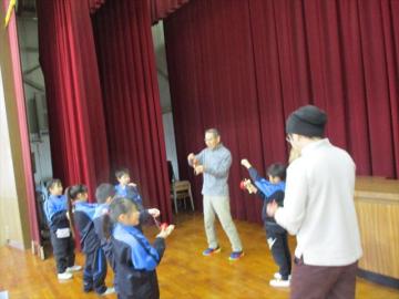 室内でけん玉教室の先生が児童に指導している様子