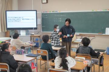 教室で担任の先生が介助のお手本を示している様子