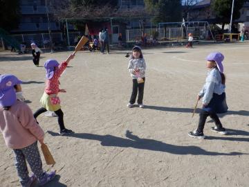 みんなで輪になって羽根つきをする幼児