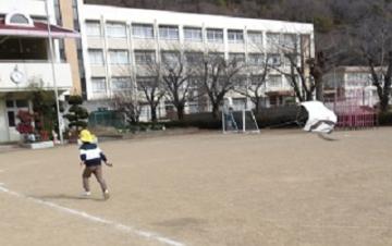 園児たちが校庭で凧あげをしている様子