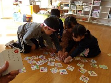 室内でかるたで真剣勝負をする園児たちの様子