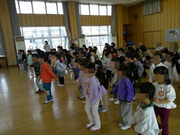 体育館に立って整列した子供たちが、歌に合わせてダンスをしている様子