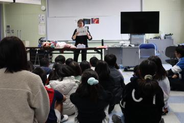 会場内で先生が写真を見せて児童たちに説明されている様子