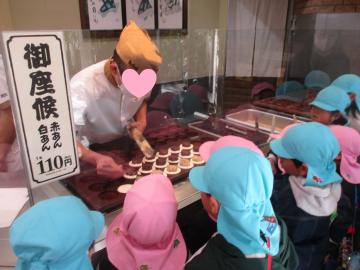 御座候が作られる様子をガラス越しに眺めている子供たち