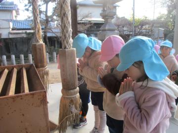神社の境内で目を目をつむって祈祷をする子供たち