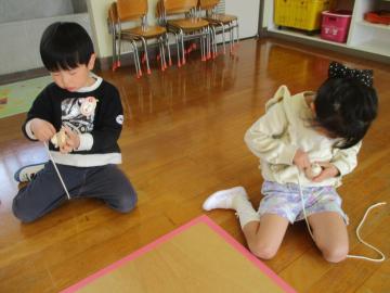 こまにひもを巻く子どもたち