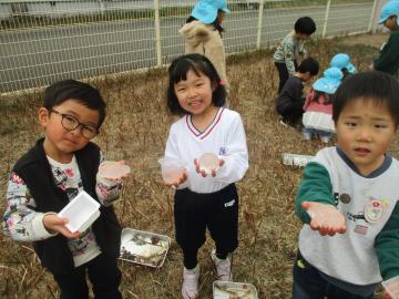 カップに水を入れてできた氷を持って見せる子供たち