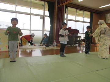 室内で、お茶会での席で、お茶菓子を真剣に運ぶ子供