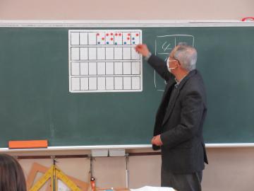 講師の方が教室で3年生に点字のしくみについて説明している様子