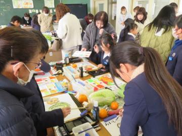 教室で絵手紙教室で冬野菜を描く4年生の様子