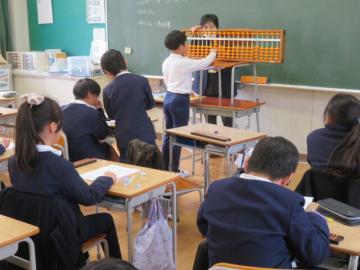教室でそろばんの玉の置き方を確認する3年生の様子