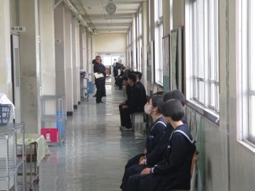 校舎内の廊下で着席し、面接の順番を待つ生徒たちの様子