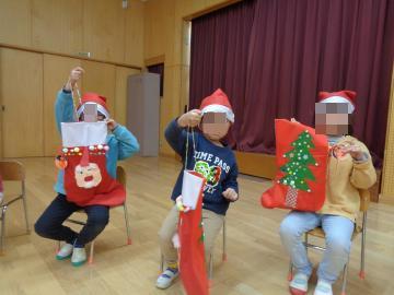 教室で椅子に座った園児がプレゼントをもらって喜んでいる