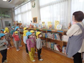 園児が小学校の図書室に行って司書の方から図書室の使い方について説明をうけている