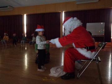 園児がサンタクロースからプレゼントをもらっている