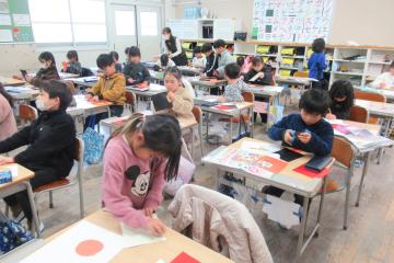 教室で1年生が色紙を切ったり糊で張ったりしている様子