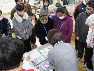 型紙を使ってパステルを塗る説明を聞いている様子
