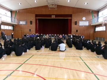体育館に座った全校生徒と壇上前に並んだ22名の講師の先生方と顔合わせの様子