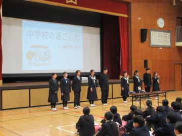 体育館の壇上前に整列し、大的中学校の一日について説明をする生徒会役員たち